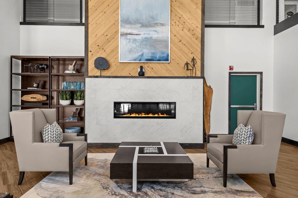 A modern living room with a fireplace and two chairs.