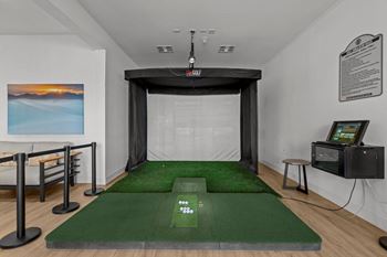 A room with a green carpet and a white wall with a painting on it.