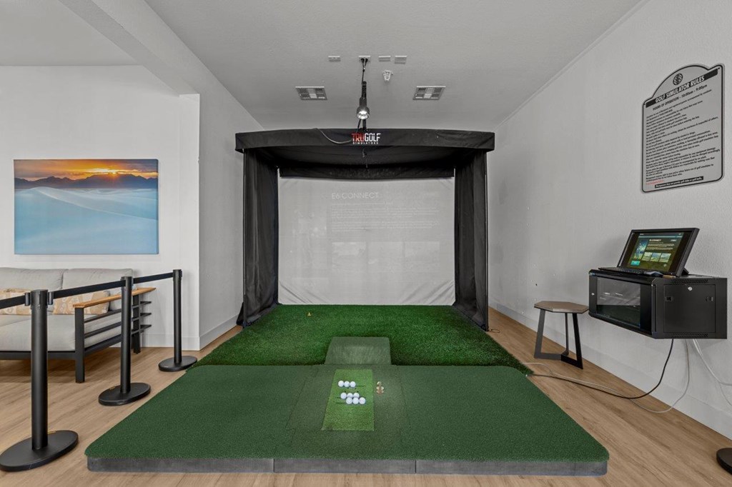 A room with a green carpet and a white wall with a painting on it.