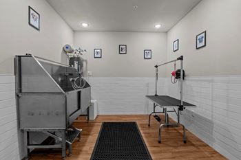 A clean, white-walled room with a stainless steel machine and table.