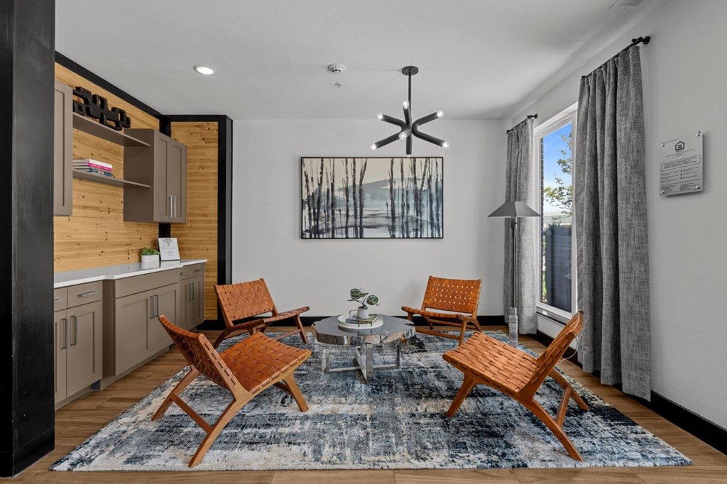 A modern living room with a wooden chair set and a rug.