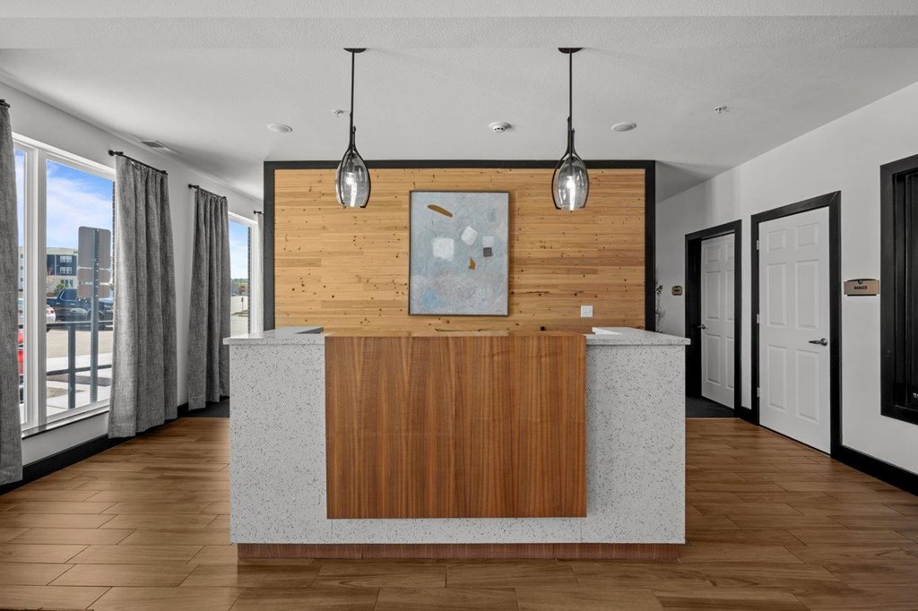 A reception area with a wooden panel and a grey counter.