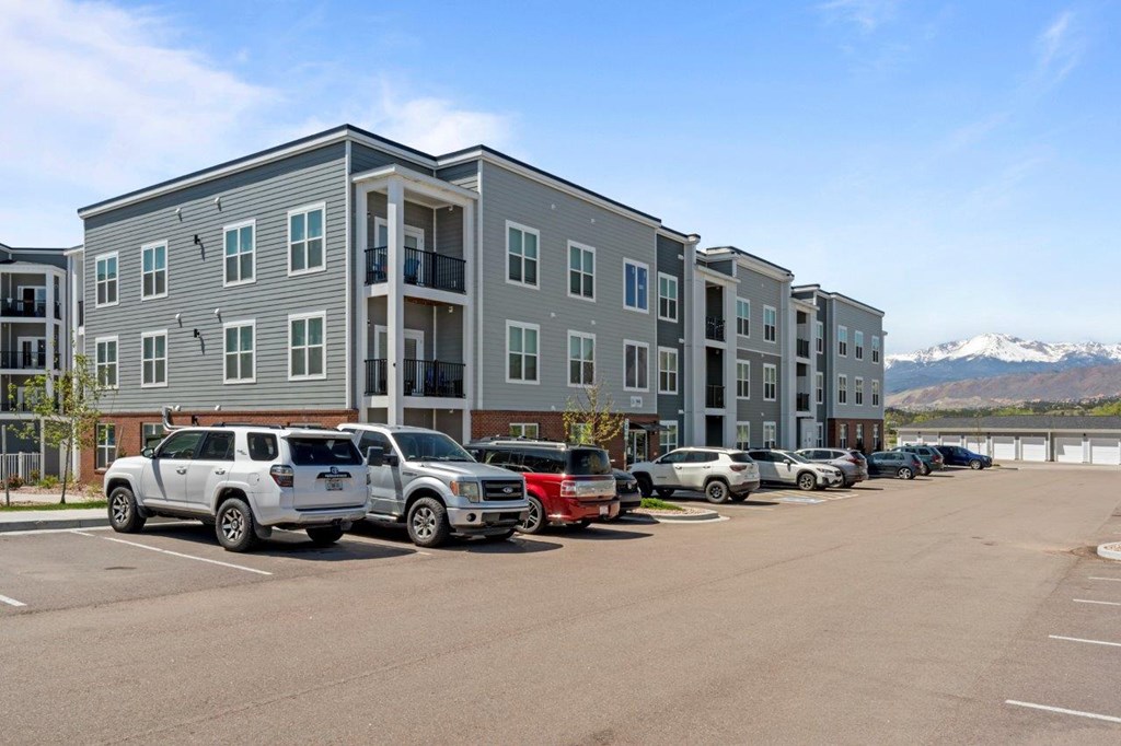A parking lot with cars and a building in the background.