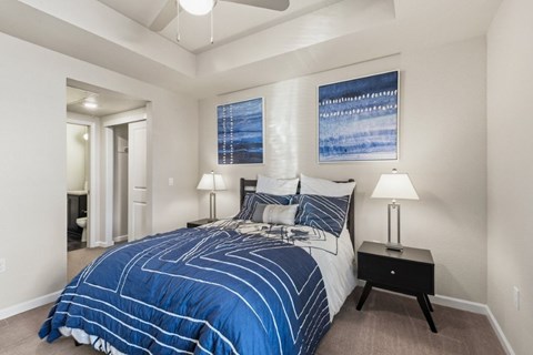 A bedroom with a large bed and a painting on the wall.
