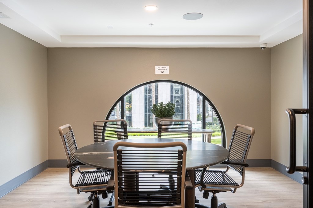 A conference room with a table and chairs and a view of the outside.