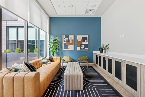 A living room with a yellow couch and a striped rug.