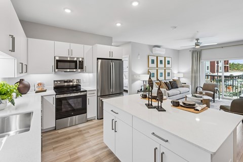 A modern kitchen with white cabinets and stainless steel appliances.