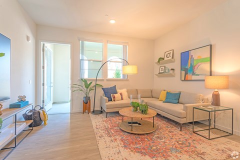 A living room with a couch, coffee table, and a painting on the wall.