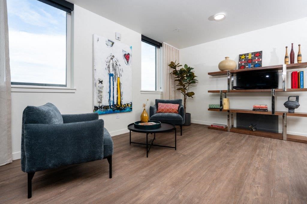 a living room with a couch and chairs and a television