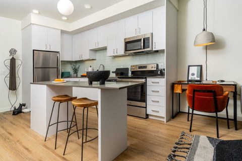 a kitchen with an island and a stove and a microwave