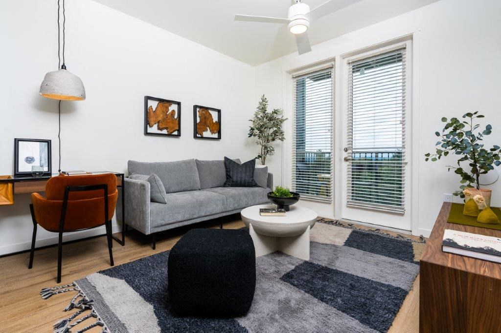 a living room with a couch and a chair and a window
