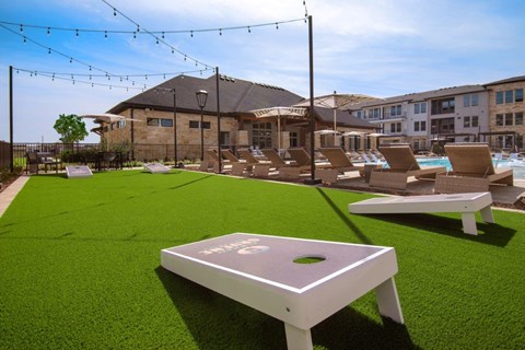 Alexan Gruene Crossing Apartments in New Braunfels, Texas Courtyard with Corn Hole
