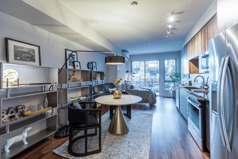a kitchen and living room with a refrigerator and a sink