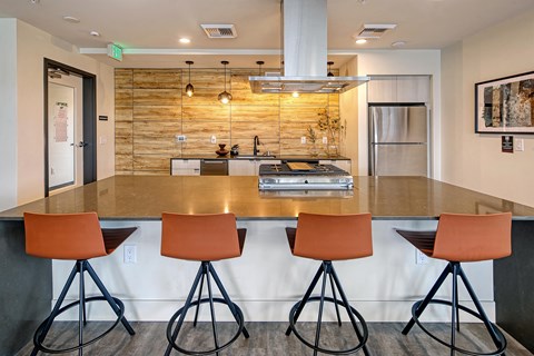 a kitchen with a large counter with four chairs