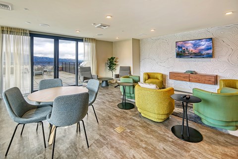 a living room with chairs and tables and a balcony