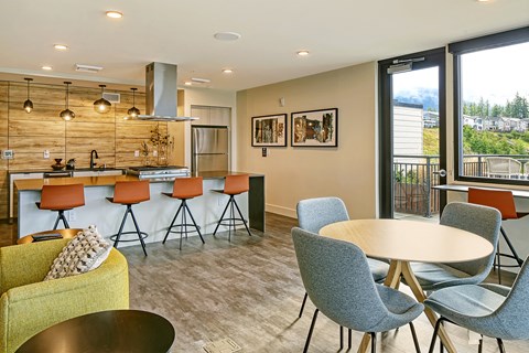 a community room with a kitchen and a table with chairs