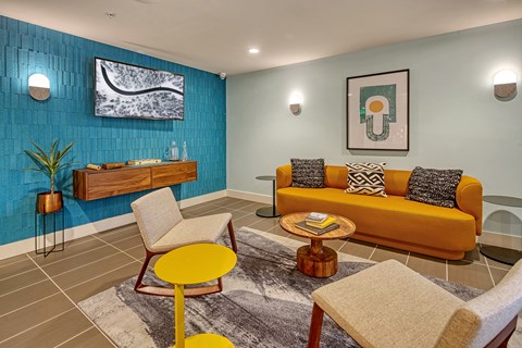 a living room with a yellow couch and a blue wall