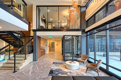 a living room with glass doors and a staircase and a table and chairs
