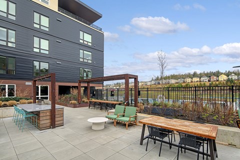 a patio with a table and chairs in front of a building