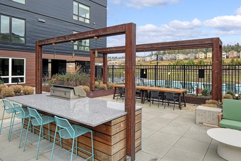 a patio with a bar and tables with chairs