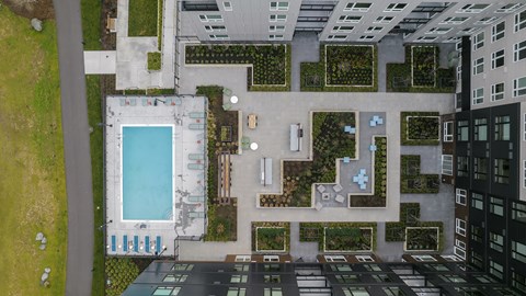 a birds eye view of a building with a pool and plants