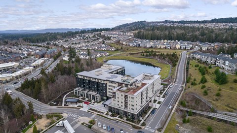 an aerial view of a building next to a lake