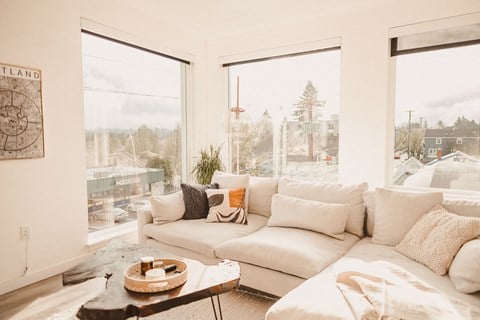 a living room with a white couch and large windows