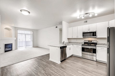 A spacious kitchen with white cabinets and stainless steel appliances.