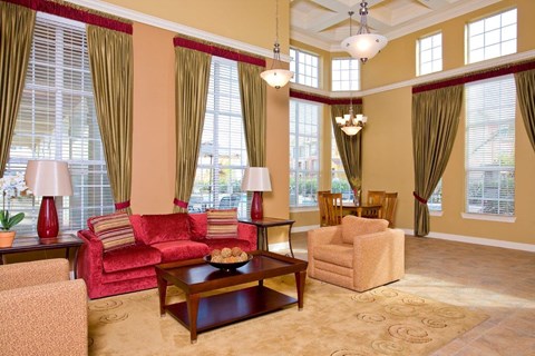 a living room with red furniture and large windows