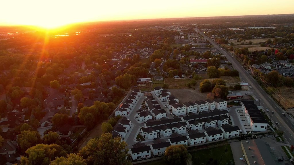 A sunset view of a residential area with houses and trees.