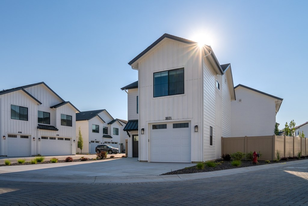 A sunny day in a residential area with houses and a clear blue sky.
