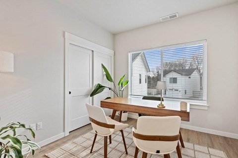 A dining room with a table and chairs.