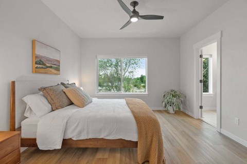 A bedroom with a large bed and a painting on the wall.