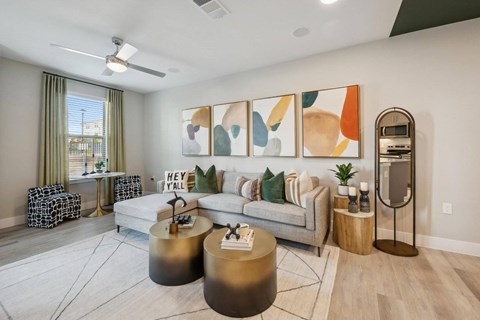 A living room with a white couch, a coffee table, and a large painting on the wall.