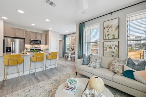 A modern kitchen with a bar area and a living room with a couch.