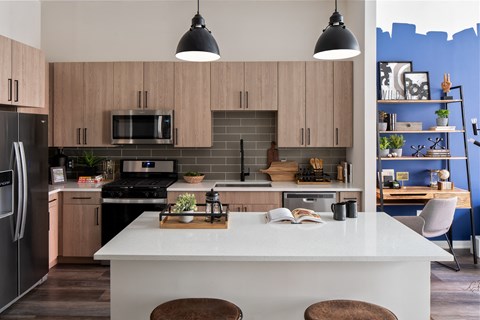 a kitchen with wooden cabinets and stainless steel appliances and a white counter top