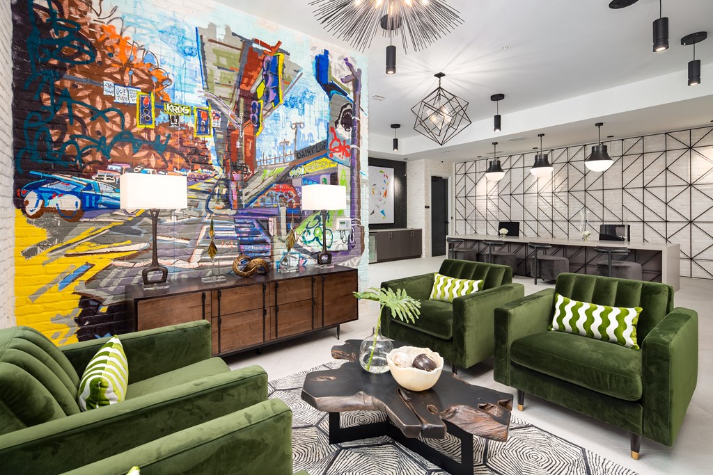 a living room with green couches and a colorful mural on the wall