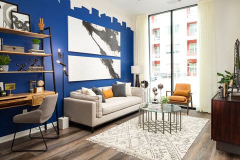a living room with a blue accent wall and a white couch