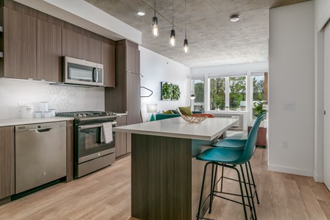 A kitchen with a white counter top and a blue chair.