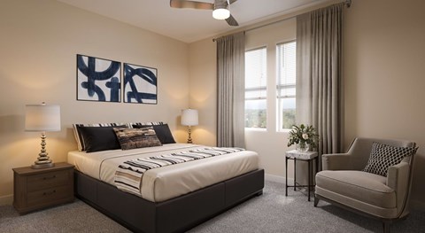A bedroom with a large bed, a chair, and a ceiling fan.