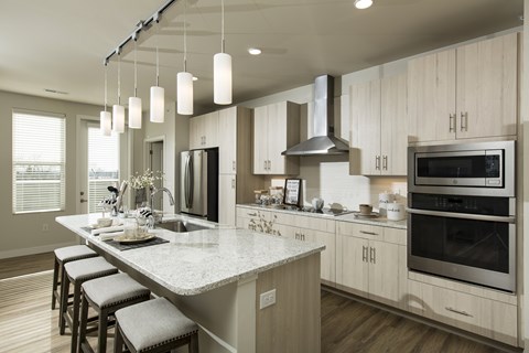 A modern kitchen with a large island and stainless steel appliances.