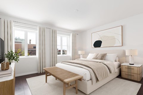 a bedroom with a bed and two windows
