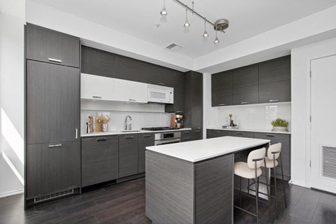 a modern kitchen with a large island and dark cabinets
