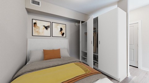 A bedroom with a bed, a yellow blanket, and two pictures on the wall.