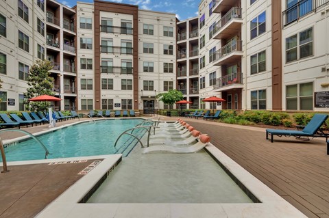 A large pool in the middle of a courtyard surrounded by apartment buildings.