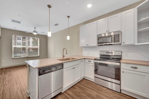 A kitchen with white cabinets and stainless steel appliances.