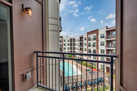A balcony with a pool and a building in the background.