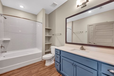 A bathroom with blue cabinets and a white sink.