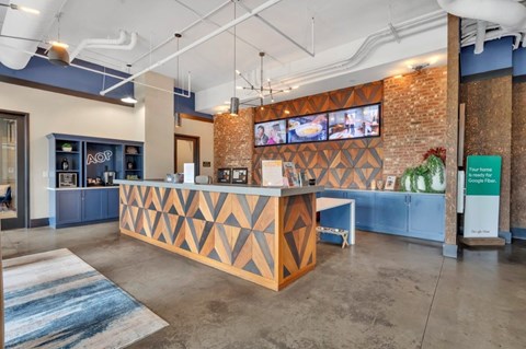 A reception area with a wooden counter and a TV mounted on the wall.