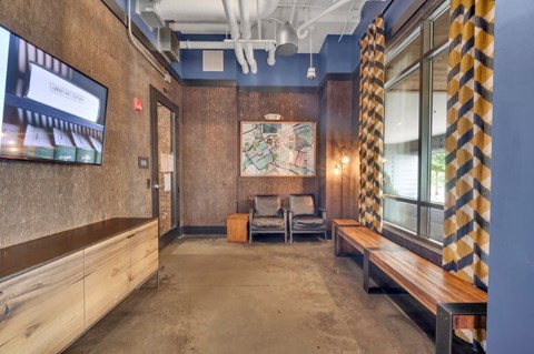 A room with a wooden bench and a television on the wall.